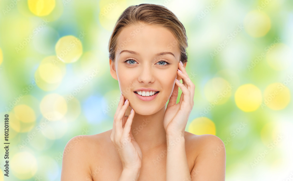 smiling young woman touching her face smiling young woman touching her face