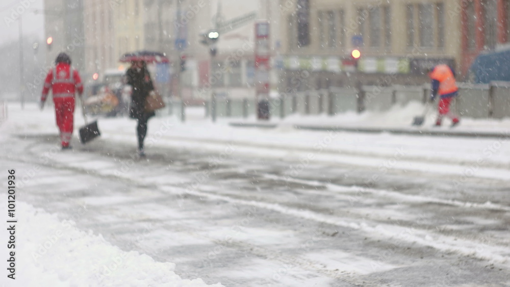 Woman walking on frozen pavement during snow storm Woman walking on frozen pavement during snow storm