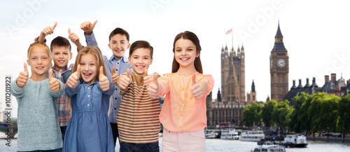 happy children showing thumbs up over london