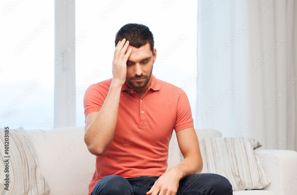 unhappy man suffering from headache at home unhappy man suffering from headache at home
