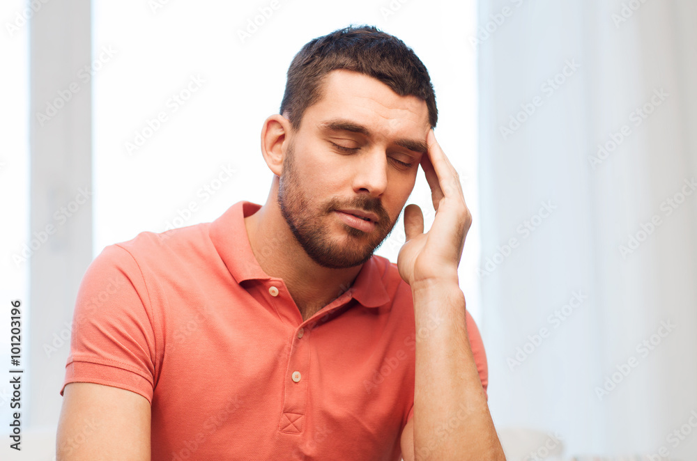 unhappy man suffering from headache at home unhappy man suffering from headache at home