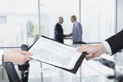 Businesswoman giving to businessman documents