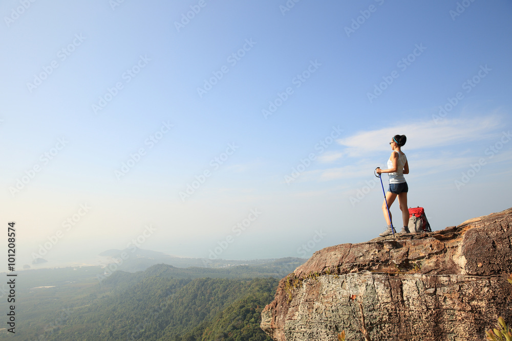 young woman backpacker enjoy the view at seaside mountain peak