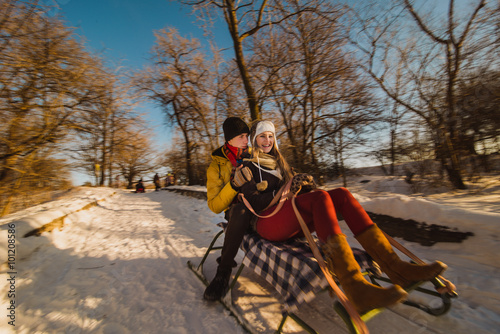 Couple play in winter with snow and sledges