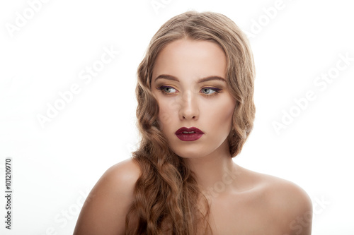 Closeup beauty portrait of young stylish woman with wavy hairstyle fashionable makeup bare shoulders on white studio background