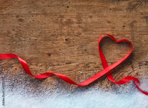 Happy Valentines Day. Red Ribbon Heart with snow on a wooden background. Valentines Day concept