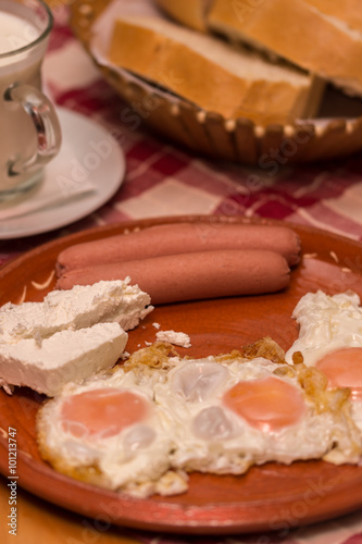 Hot dogs cheese yogurt and eggs served for breakfast