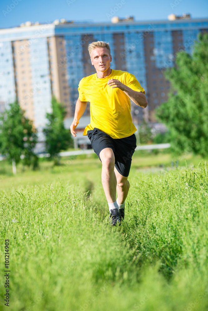 Sporty man jogging in city street park. Outdoor fitness. Sporty man jogging in city street park. Outdoor fitness.