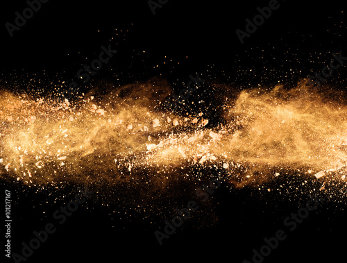 Explosion of orange powder on black background