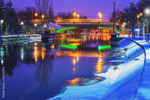 Frozen river and a bridge at night