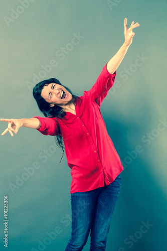 success concept - mad 30s woman laughing with wild body language for joy or satisfaction,studio shot, blue effects..
