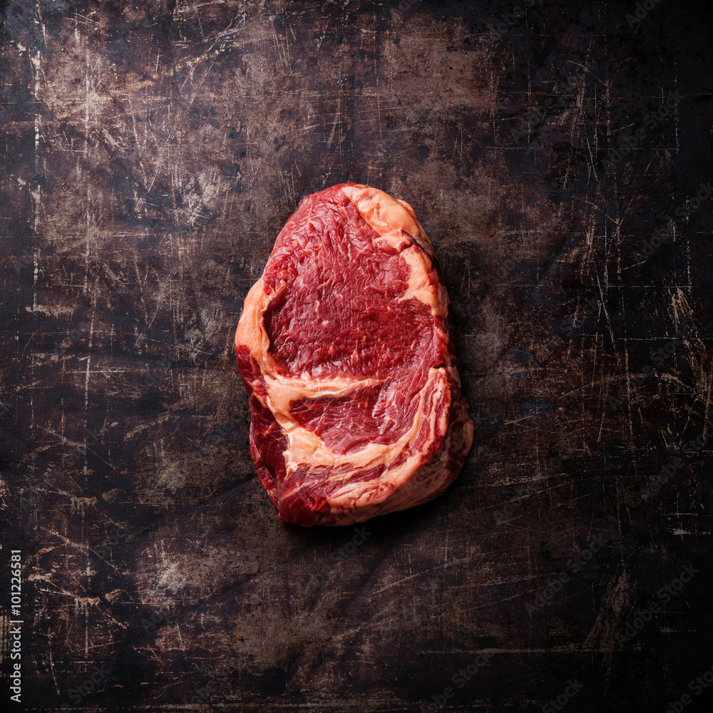 Raw fresh meat Ribeye Steak on dark metal background