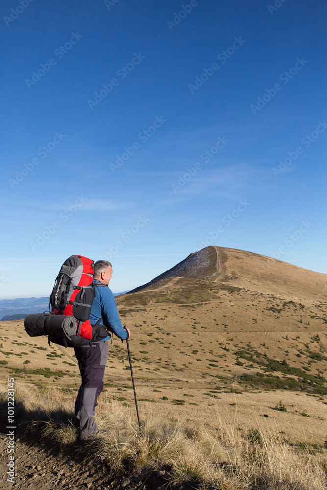 Man hiking in the mountains with a backpack and tent. Man hiking in the mountains with a backpack and tent.
