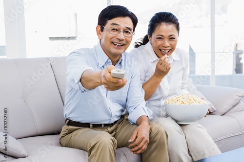 Smiling man and woman sitting on couch