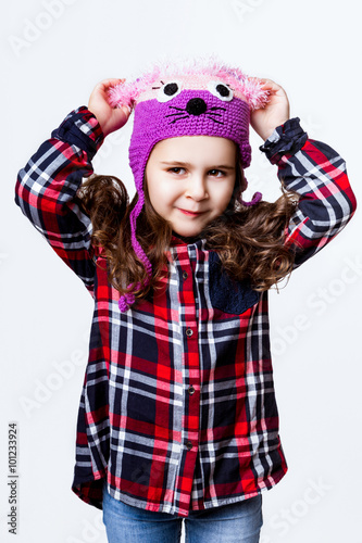 A little girl is in the cap of mouse. Studio photo
