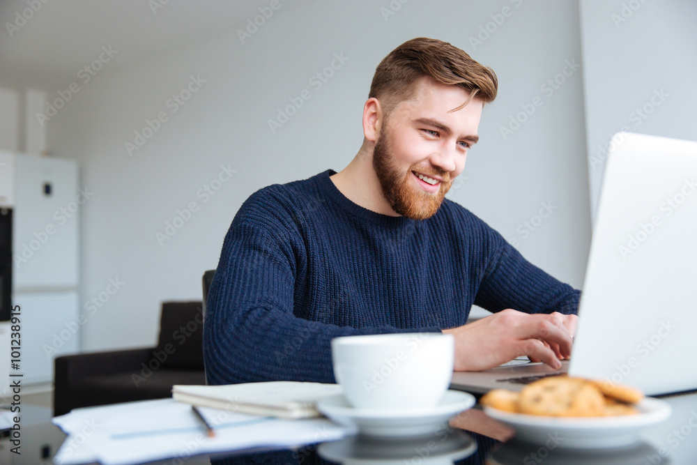 Smiling man using laptop computer at home Smiling man using laptop computer at home