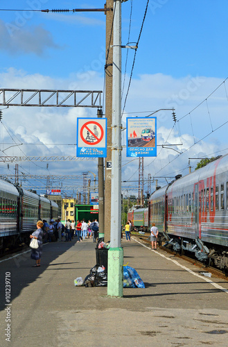 Платформа железнодорожной станции с двумя стоящими поездами дальнего следования
