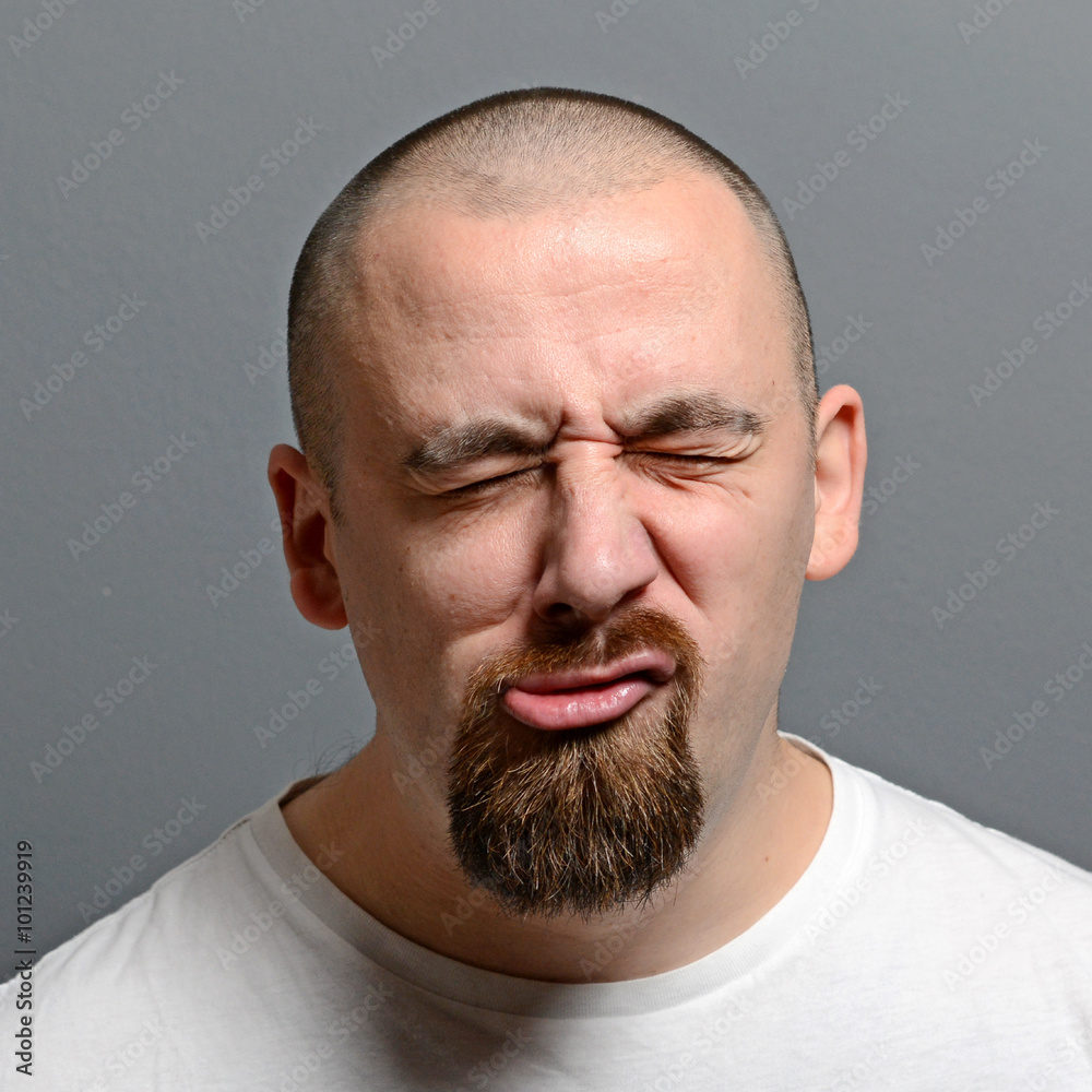 Portrait of a man making funny face against gray background Portrait of a man making funny face against gray background