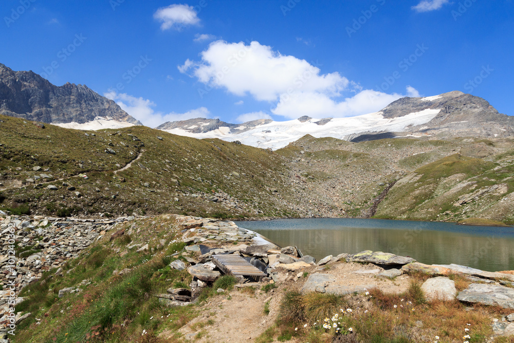 Footpath, lake and glacier panorama with mountain Kristallwand in Hohe Tauern Alps, Austria