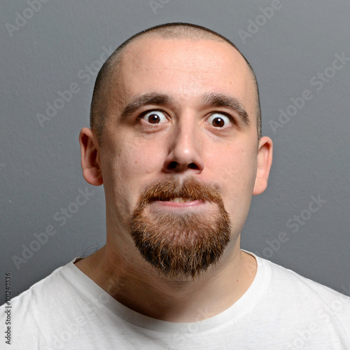 Portrait of a man making funny face against gray background