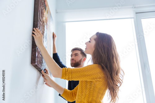 Couple hanging picture on the wall