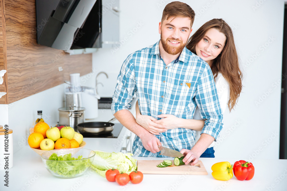 Happy couple cooking and hugging on kitchen Happy couple cooking and hugging on kitchen