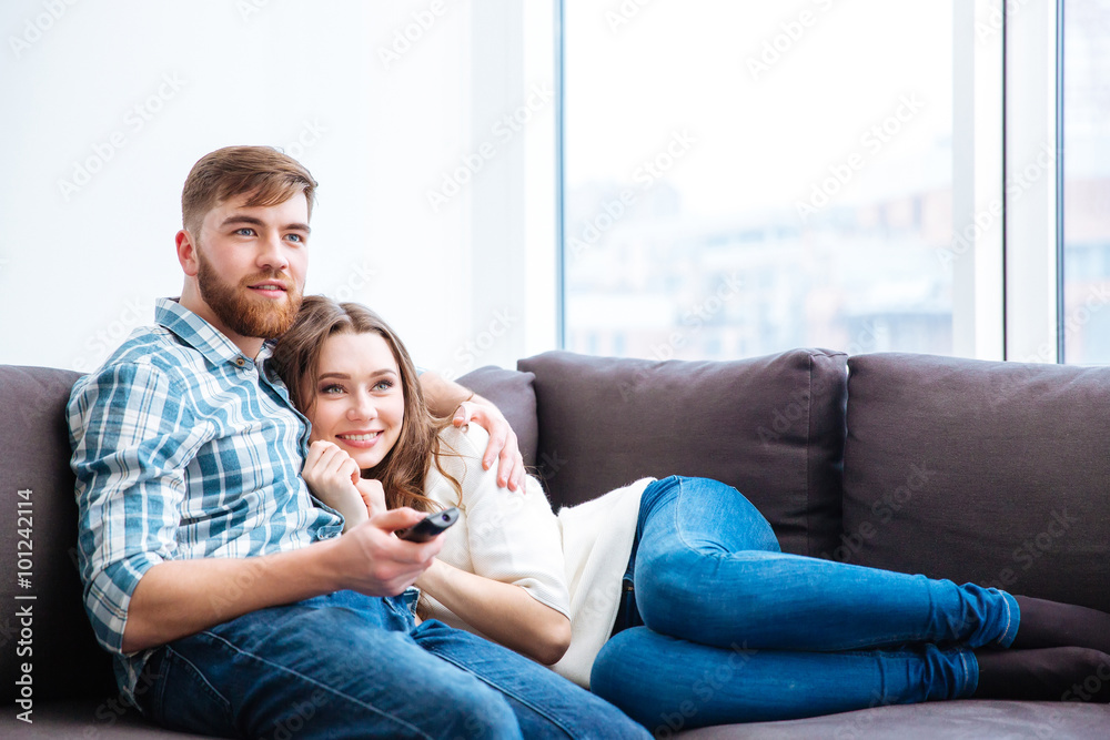 Couple watching TV on the sofa at home