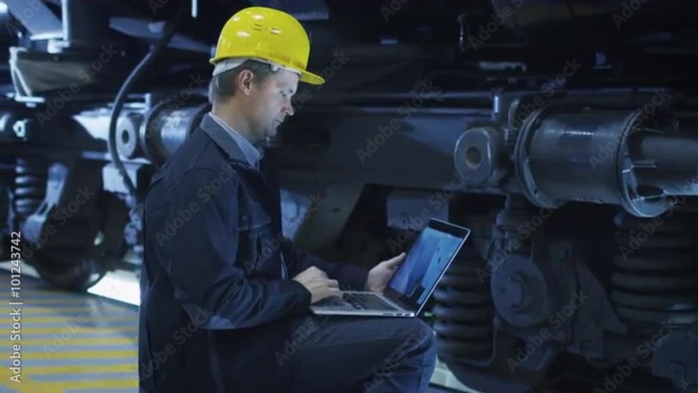 Technician in Hard Hat Using CAD Program on Laptop. Shot on RED Cinema Camera.