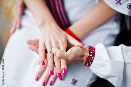 Hand of couple on traditional dress in love