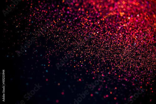 Red shiny glitter on black background. Macro shot, shalow DOF. photo