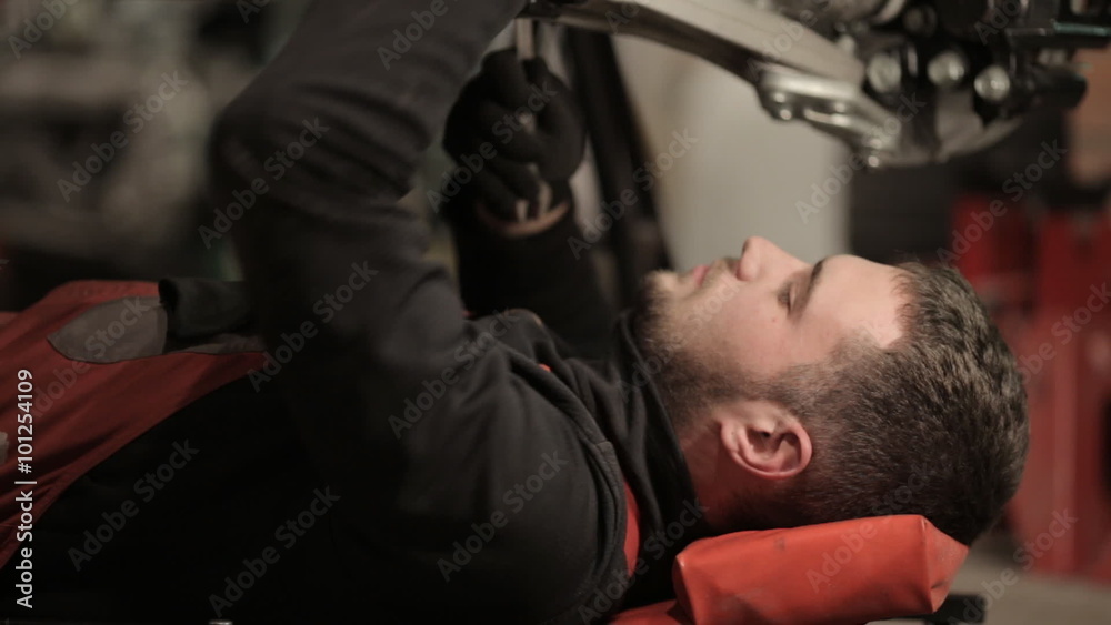 Young mechanic in red overalls engaged manual assembly machines Young mechanic in red overalls engaged manual assembly machines