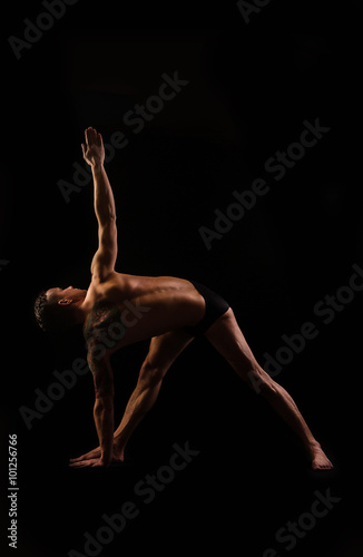muscular powerful man practicing yoga asana, pose triangle © lokisurina