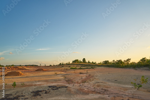 Tropical laterite soil or red earth background. Red mars seamless sand background.with blue sky.