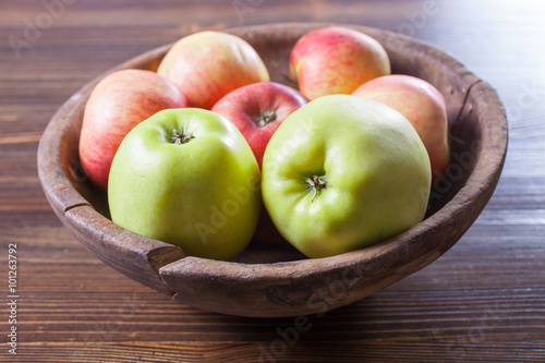 apples in an old wooden bowl on a table, selective focus