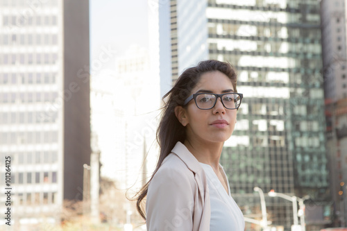 Young latin professional woman with glasses in the city