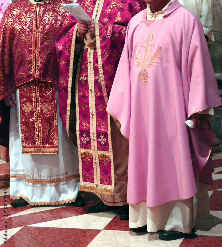  priests with cassock in church during the Holy Mass