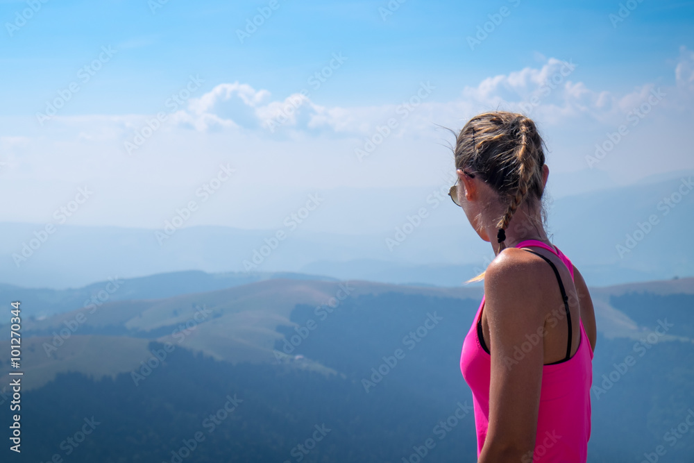 Young woman on top of the mountain and look the blue sky and the panorama Young woman on top of the mountain and look the blue sky and the panorama