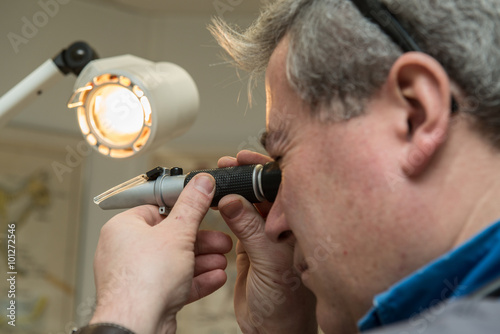 vétérinaire analyse au prisme ou au microscope les virus dans le sang de l'animal domestique le chat le chien le nac. Un écran permet au propriétaire de l'animal de comprendre le mal. photo