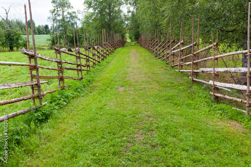 Old traditional wooden fence and road