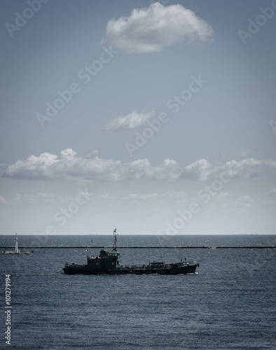 Foto tug boat maneuvering near the pier