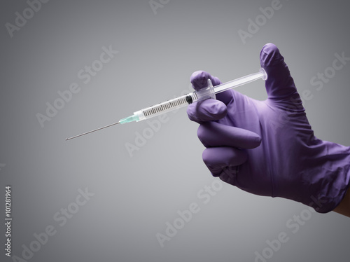 Doctor holding medical syringe photo