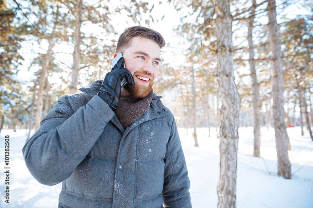 Happy man talking on the phone in winter park Happy man talking on the phone in winter park