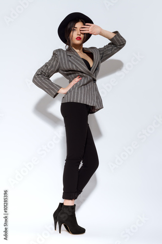 Handsome Fashion Woman With Hat In Suit Posing On Gray Backgroun