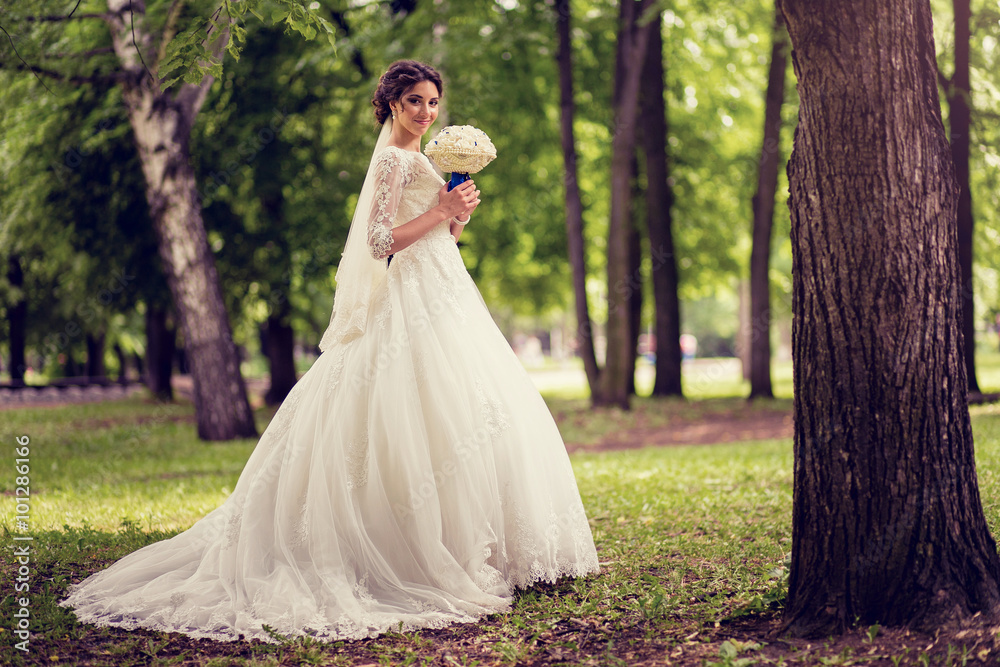 Elegant bride in wedding dress with dipped hem in full length
