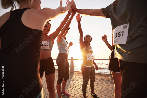 Runners high fiving each other after a race