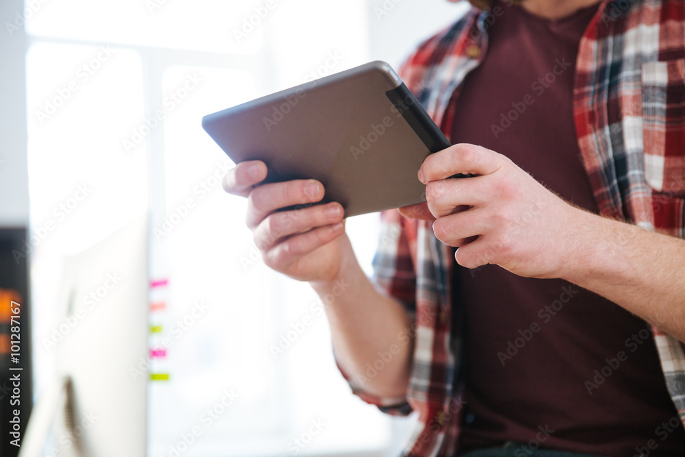 Closeup of tablet used by man in checkered shirt Closeup of tablet used by man in checkered shirt