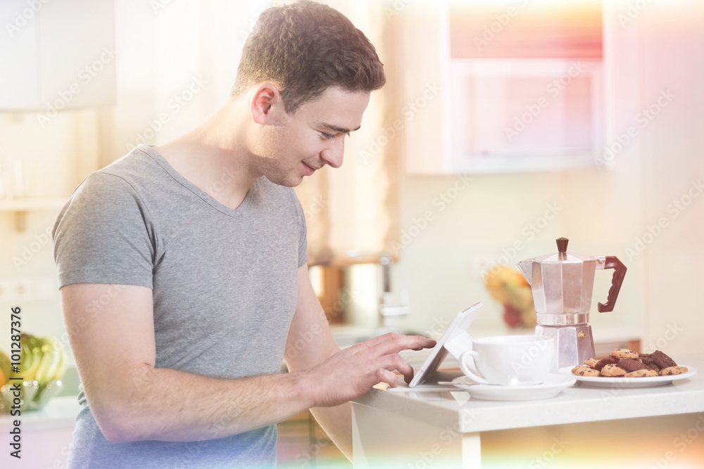 Mann informiert sich morgens beim Kaffee mit Tablet online Mann informiert sich morgens beim Kaffee mit Tablet online