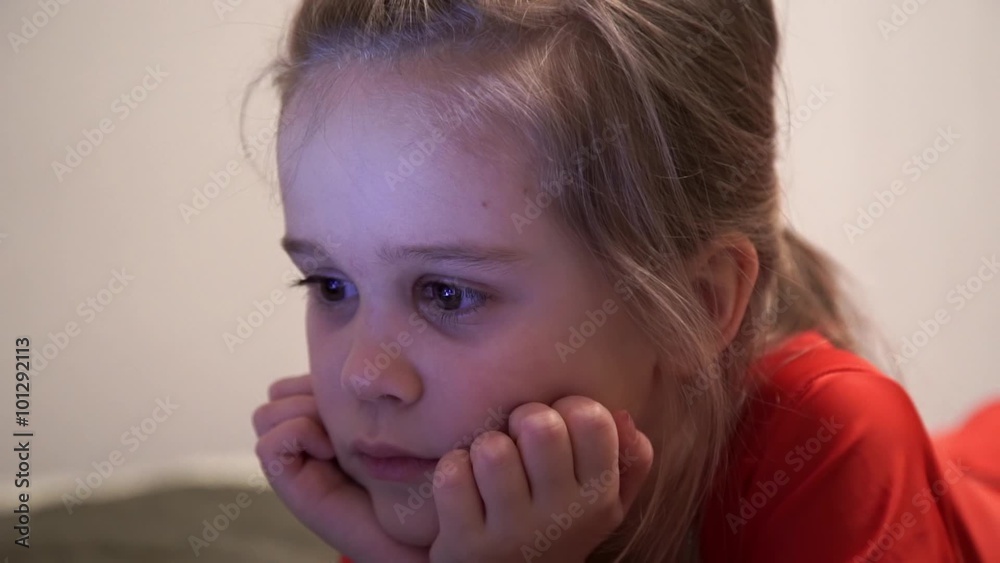 Little girl at night watching cartoons at computer.