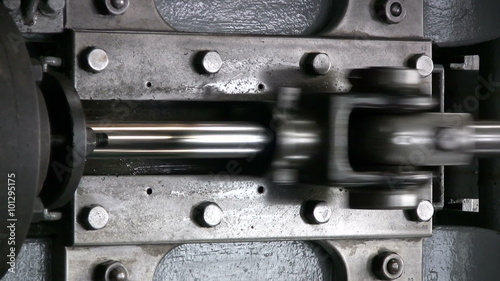 Stationary steam engine in operation with emphasis on the piston, slide and connecting rod which connects to the crank, changing linear motion to rotary motion.