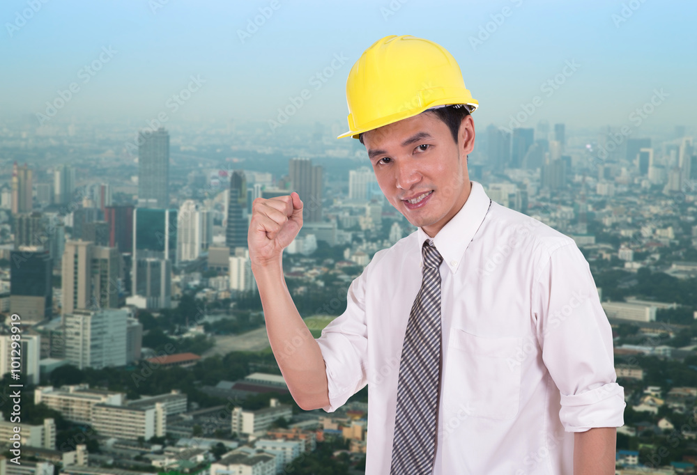 Happy engineer with arm raised, concept of successful, city back Happy engineer with arm raised, concept of successful, city back